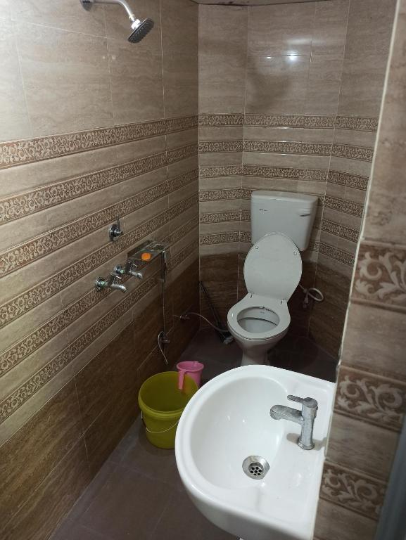 a bathroom with a white sink and a toilet at Hari Kripa Sadan in Ayodhya