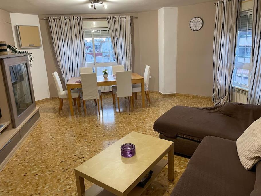 sala de estar con sofá y mesa con sillas en Precioso apartamento junto al centro con garaje en Valencia