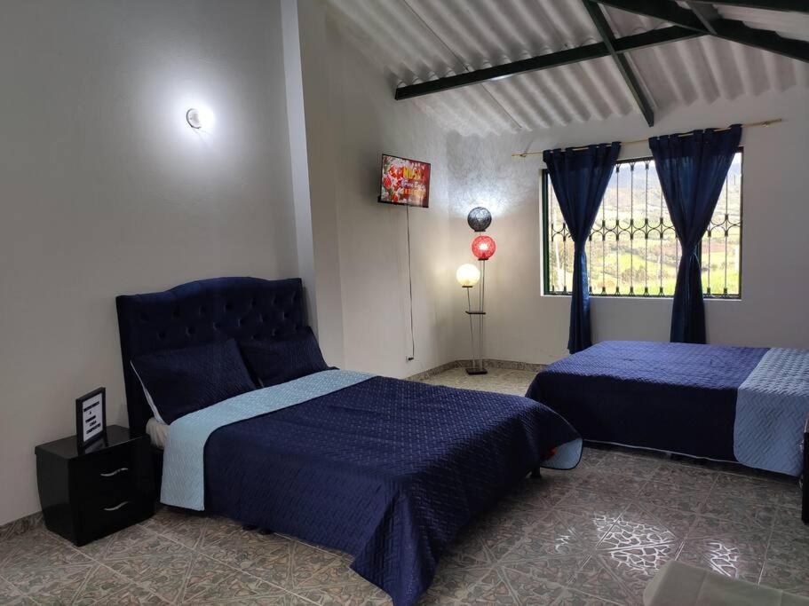 een slaapkamer met 2 bedden en een raam bij Yinkana Casa Campestre in Guatavita