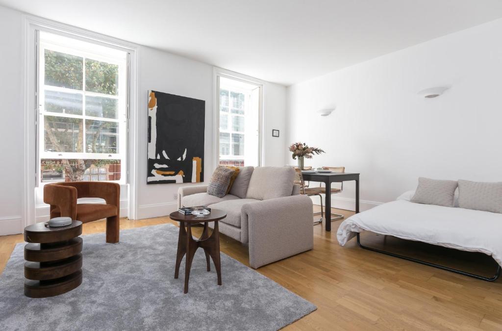 a white living room with a bed and a couch at Generously large 1 bedroom apartment in Farringdon in London