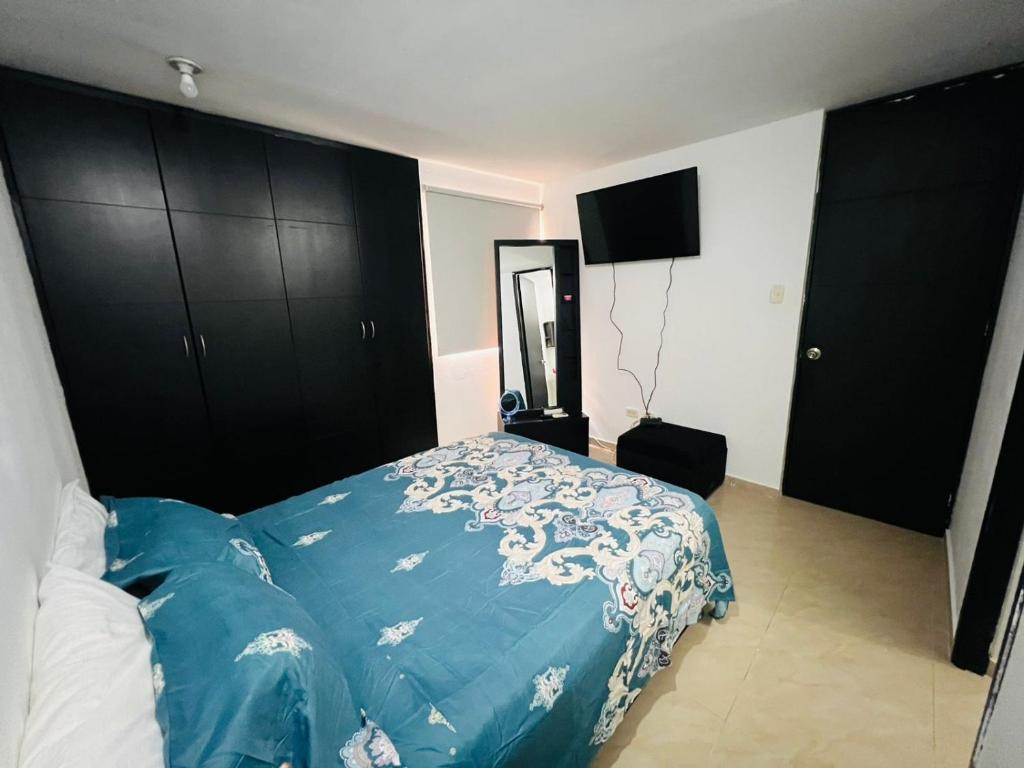 um quarto com uma cama azul e armários pretos em adriana sofia cartagena em Cartagena das Índias