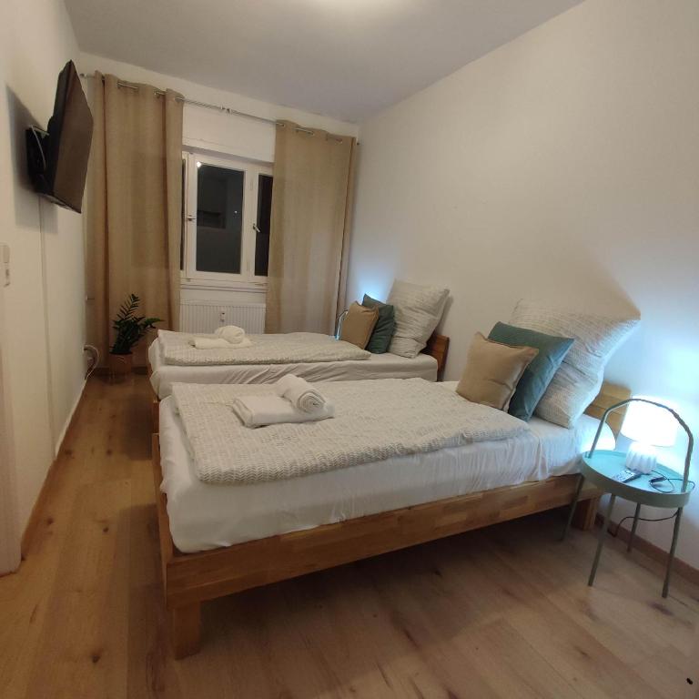 a bedroom with two beds and a television in it at Praktisch und Gut in der Goldstadt in Pforzheim