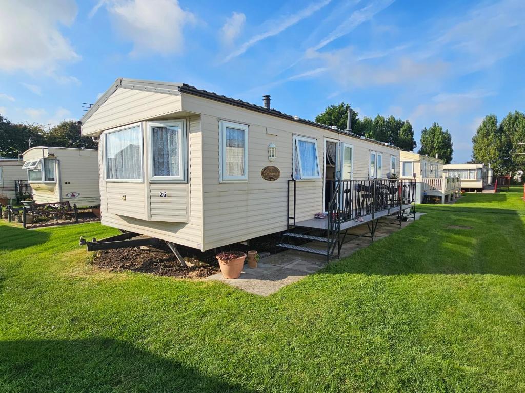 a white tiny house in a yard at Liberty Caravan Hire in Chapel Saint Leonards