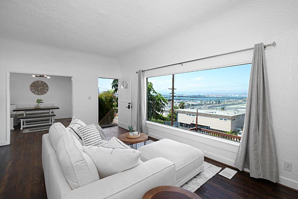 a living room with a white couch and a large window at Breathtaking Bayview home in San Diego