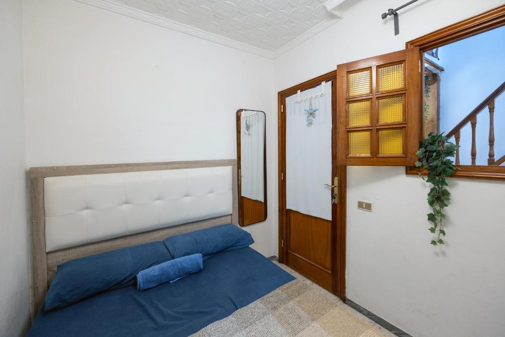 a bedroom with a blue bed and a door at Kite & Surf Nomad House in Las Palmas de Gran Canaria