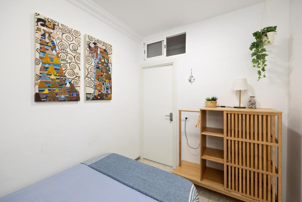 a bedroom with a bed and a painting on the wall at Kite & Surf Nomad House in Las Palmas de Gran Canaria