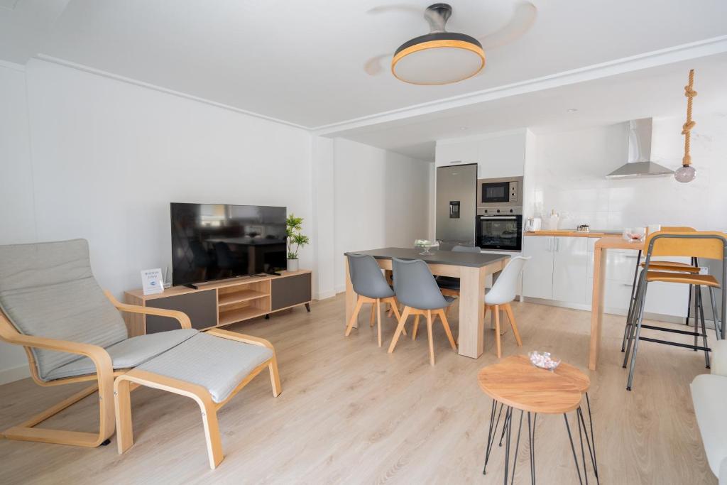 a living room with a table and chairs and a kitchen at Apartamento en Gran Playa in Santa Pola