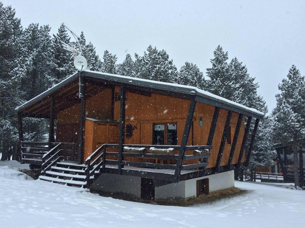 een houten hut in de sneeuw met een sneeuwval bij Chalet de montaña in Bolquere Pyrenees 2000