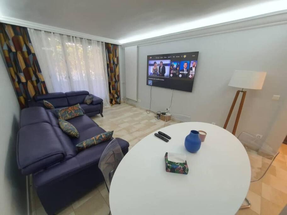 sala de estar con mesa blanca y sofá en Appartement meublé de 77 m² Champigny-Sur-Marne, en Champigny-sur-Marne