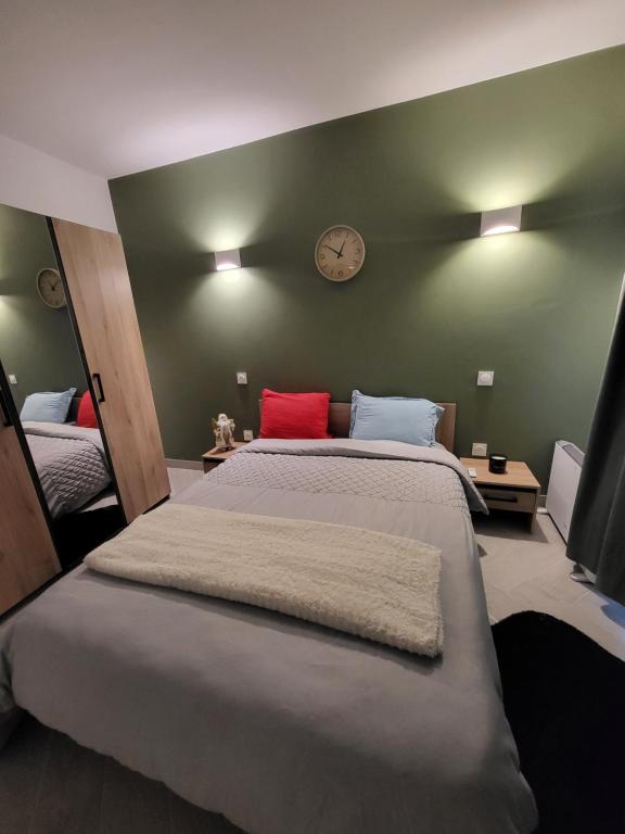 a bedroom with a large bed with a clock on the wall at Lovely studio -paris in Bagnolet