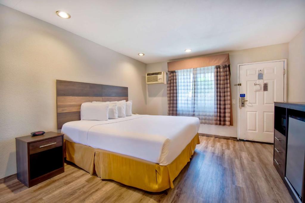 a hotel room with a large bed and a television at Studio 6 Rosemead, CA in Rosemead