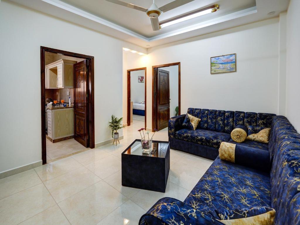 sala de estar con sofá azul y mesa en ENG-Murjan Apartment en Áqaba