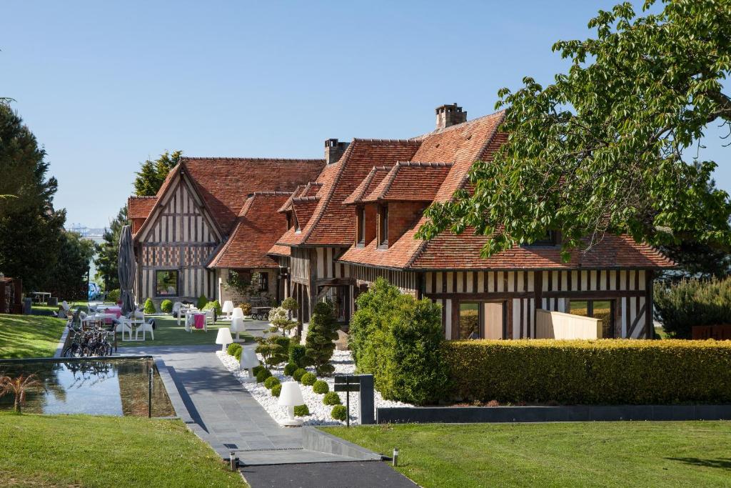 a house with a pond in front of it at La Chaumière in Honfleur