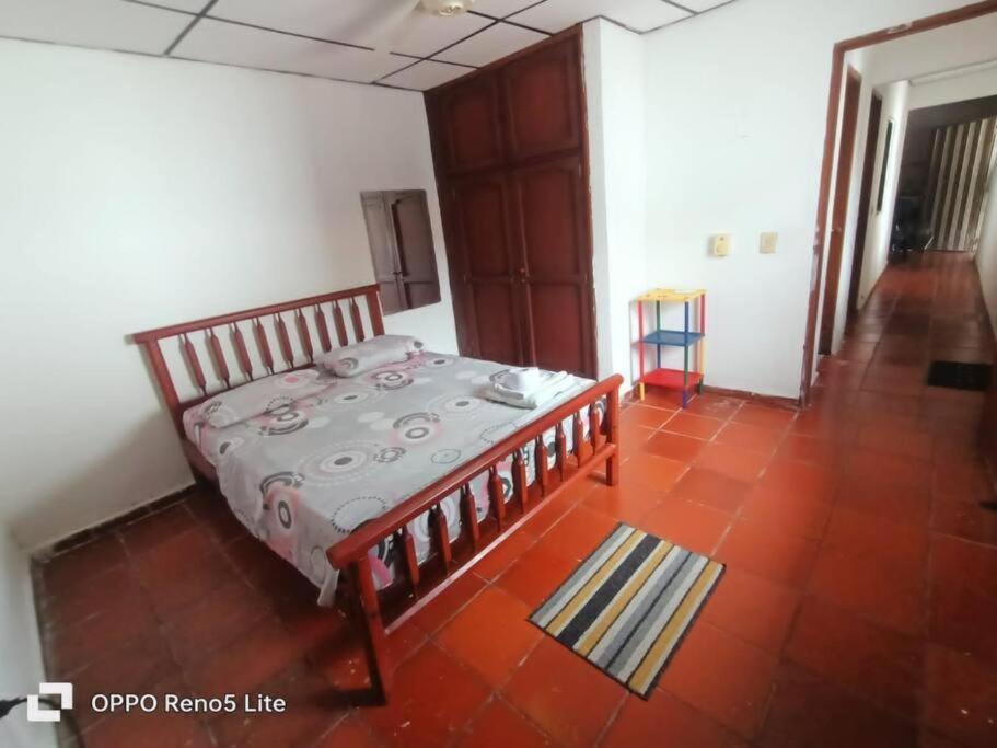 Hospedaje Doña Victoria في سانتا مارتا: غرفة نوم بسرير وأرضية من البلاط الأحمر