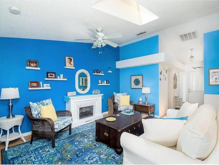 a living room with blue walls and a ceiling fan at Charming Vintage Haven in Tarpon Springs