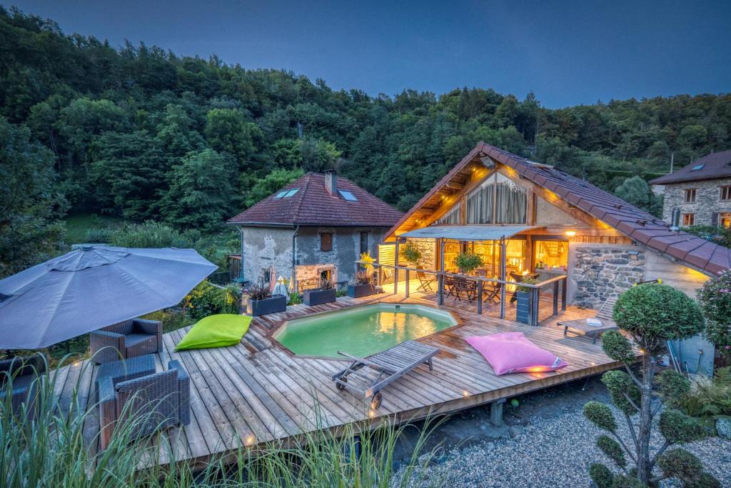 une terrasse avec une piscine et une maison dans l'établissement Le Chalet des Eaux - Thermes - Ski, à Revel