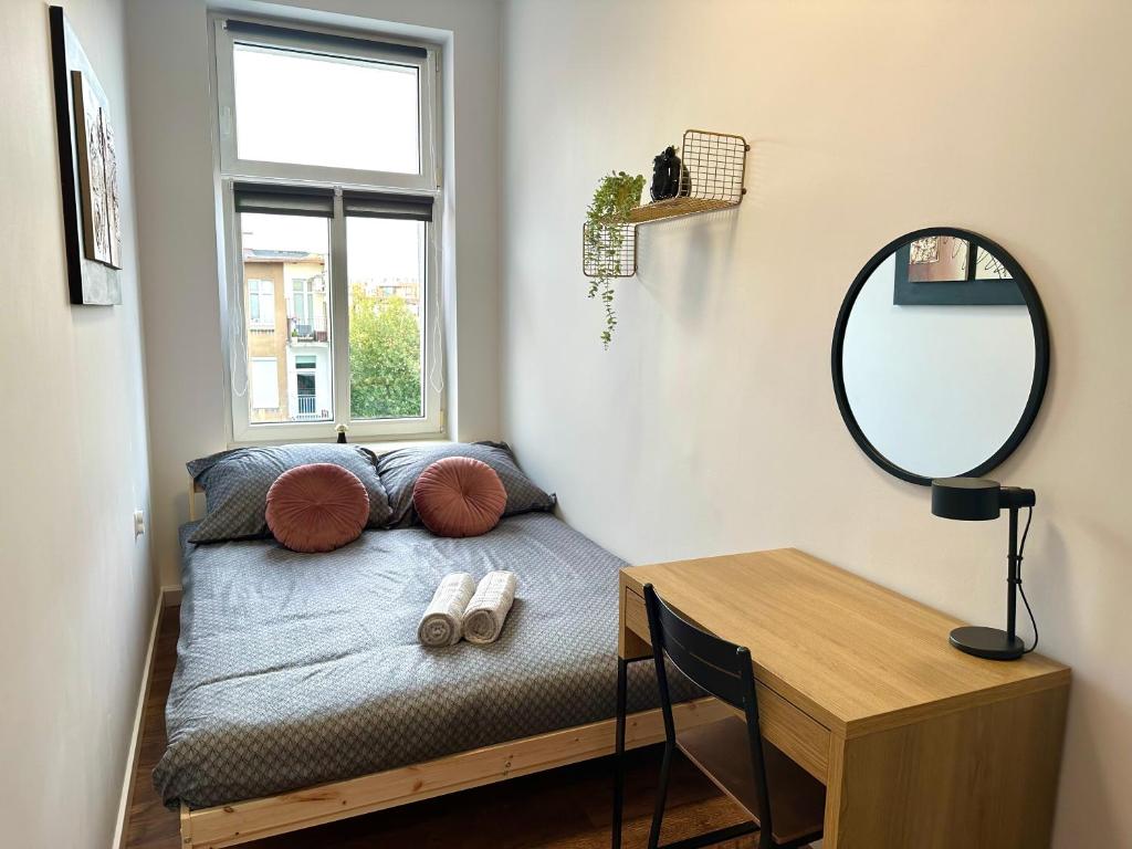 a bed in a room with a mirror and a table at MMRent Swamp Room in Gdańsk