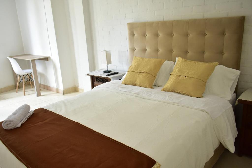 a bedroom with a large white bed with yellow pillows at Vive como un local en Popayan in Popayan