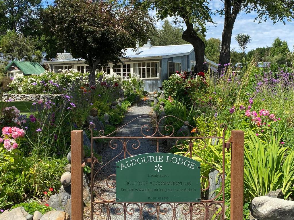 a garden with a welcome sign in front of a house at Aldourie Lodge in Lake Tekapo