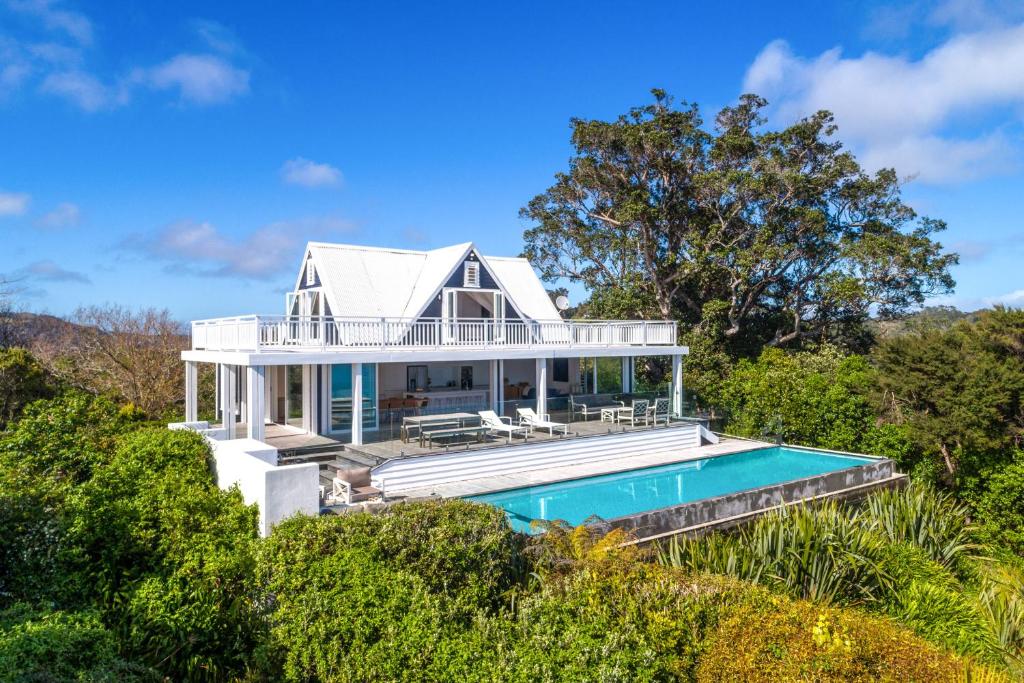 a home with a swimming pool and a house at Min Y Mor in Onetangi