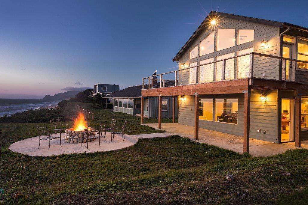 a house with a fire pit in front of it at Pacific Breeze in Lincoln City