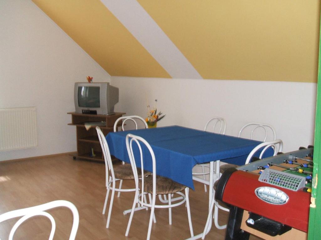 uma sala de jantar com uma mesa azul e cadeiras em Feherszeker apartmanok em Abádszalók
