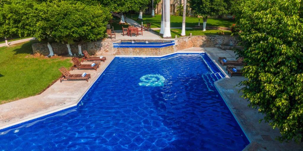 an overhead view of a blue swimming pool with chairs at Hotel Loma Real in Tapachula