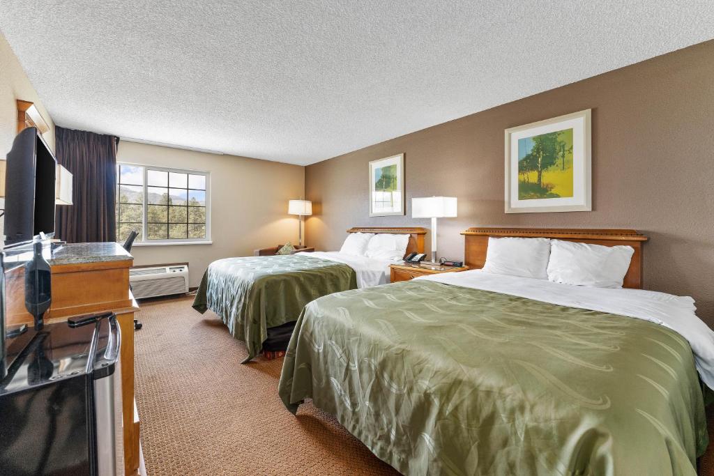 a hotel room with two beds and a flat screen tv at Quality Inn & Suites Okanogan - Omak in Okanogan