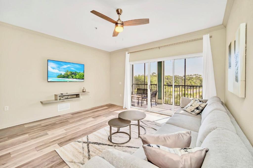 uma sala de estar com um sofá e uma ventoinha de tecto em 3BR Condo - Near Disney Balcony Pool Hot tub em Orlando