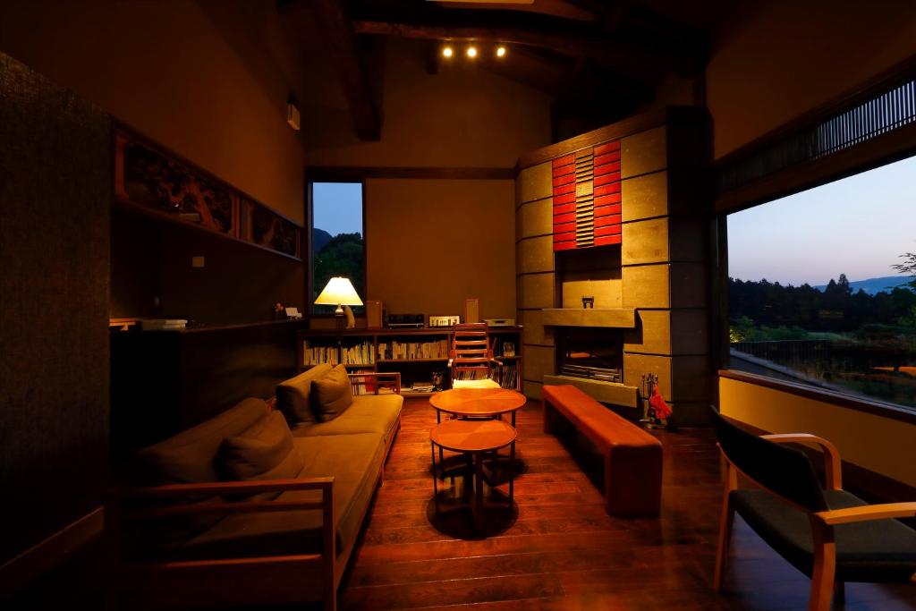 a living room with a couch and a fireplace at Ryokan Konomama in Minami Aso