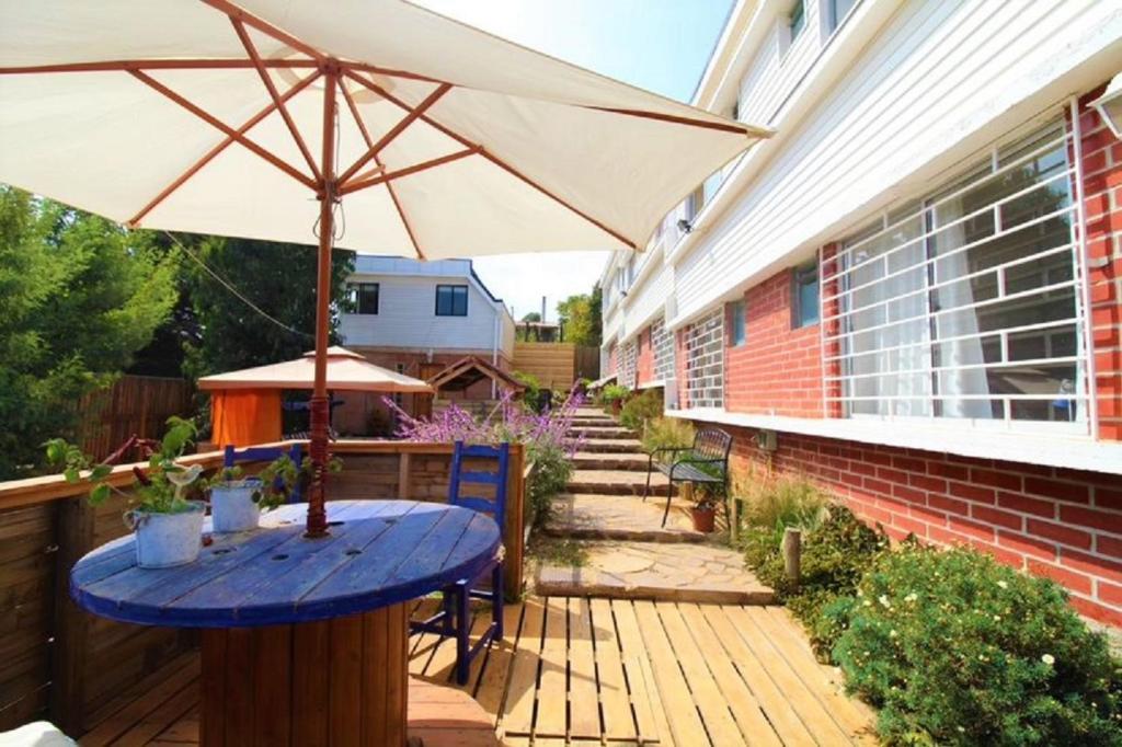 a patio with a blue table and an umbrella at Hostal Napoli in Valparaíso