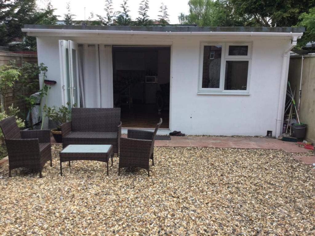 a patio with chairs and a table in front of a house at Studio with own Garden in London