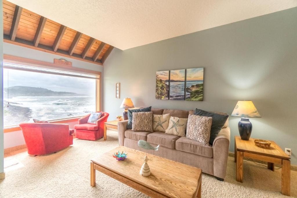 a living room with a couch and a large window at Admiral 3 in Depoe Bay