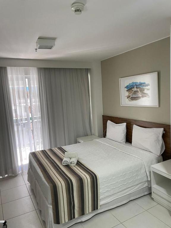 um quarto com uma cama grande e um cobertor listrado em FLAT FUSION em Brasília