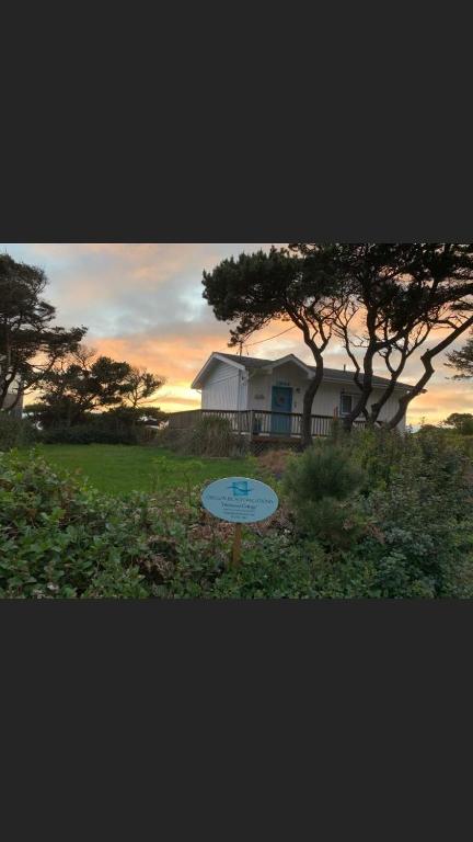 a frisbee in front of a house with a tree at Driftwood Cottage in Seal Rock