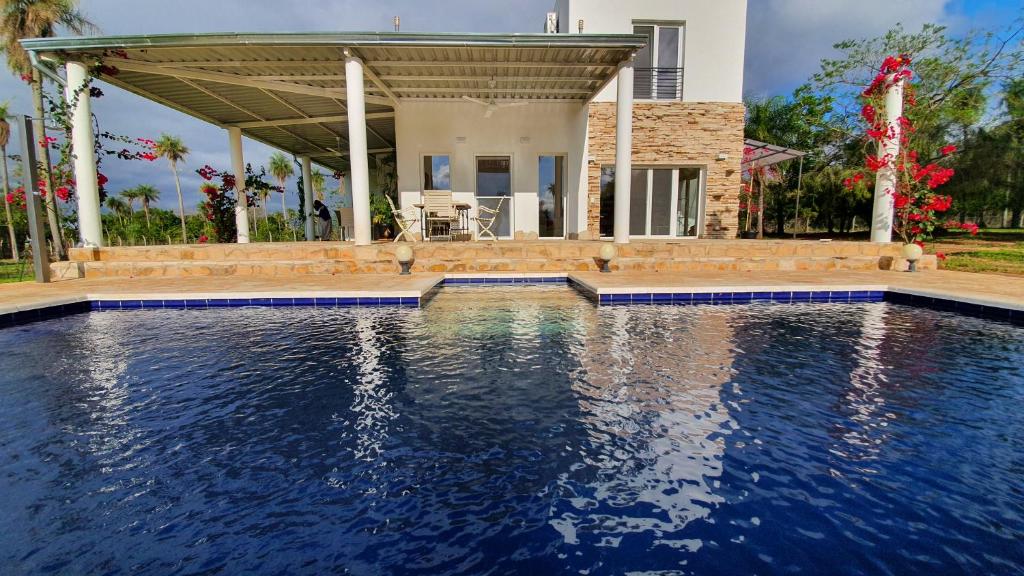 a swimming pool in front of a house at Residencia de Coco, Künstlerhaus in Piribebuy, in Piribebuy