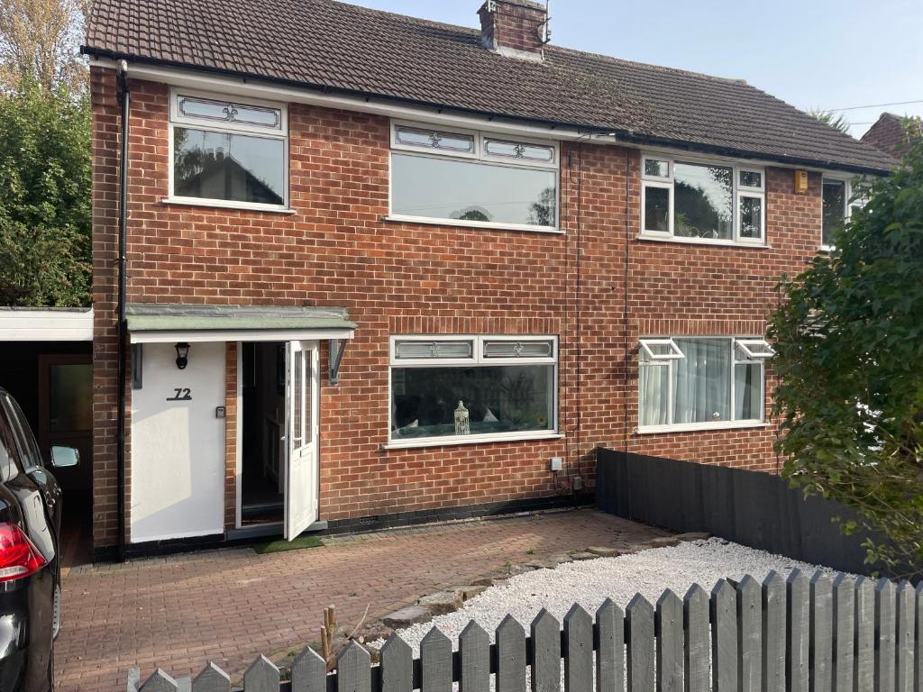 ein Backsteinhaus mit einem Hund am Fenster in der Unterkunft White House Villa in Nottingham