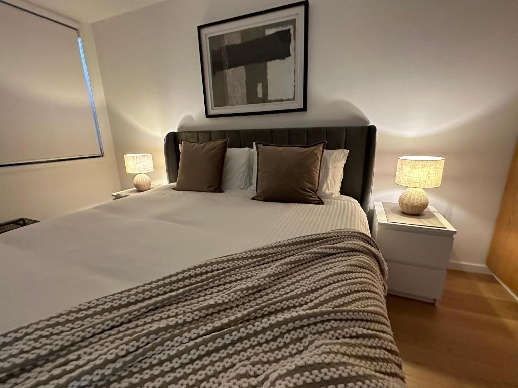 a bedroom with a large bed and two lamps at Palko - Oasis in the City in Canberra