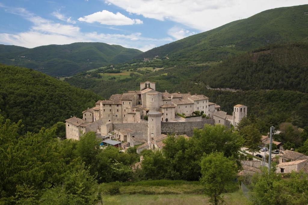 Il Tripode - Le Dimore del Bordone في Vallo di Nera: قلعة كبيرة وسط جبل