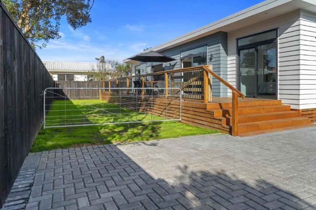 a house with a fence and a porch at Recline on Leo in Waihi Beach