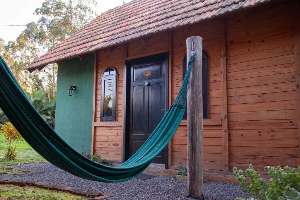 a hammock in front of a log cabin at Chalé Alpino in Apiúna