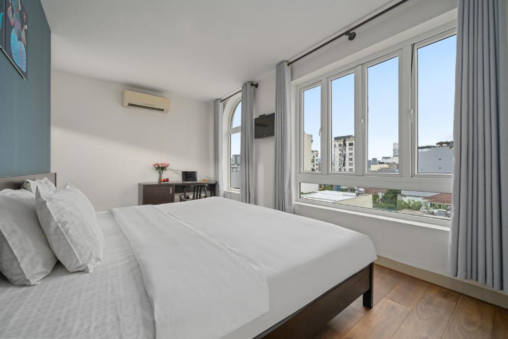 1 dormitorio blanco con 1 cama grande y ventanas en Gold Time Hotel Da Nang, en Da Nang