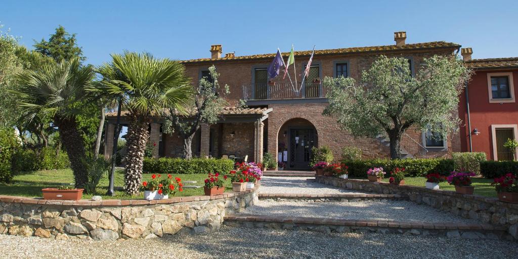 a house with flowers and plants in front of it at Casale Etrusco in Bolgheri