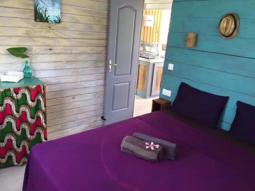 a bedroom with a purple bed with a purple blanket at LE BUNGA gîte côté canne in Grand-Bourg