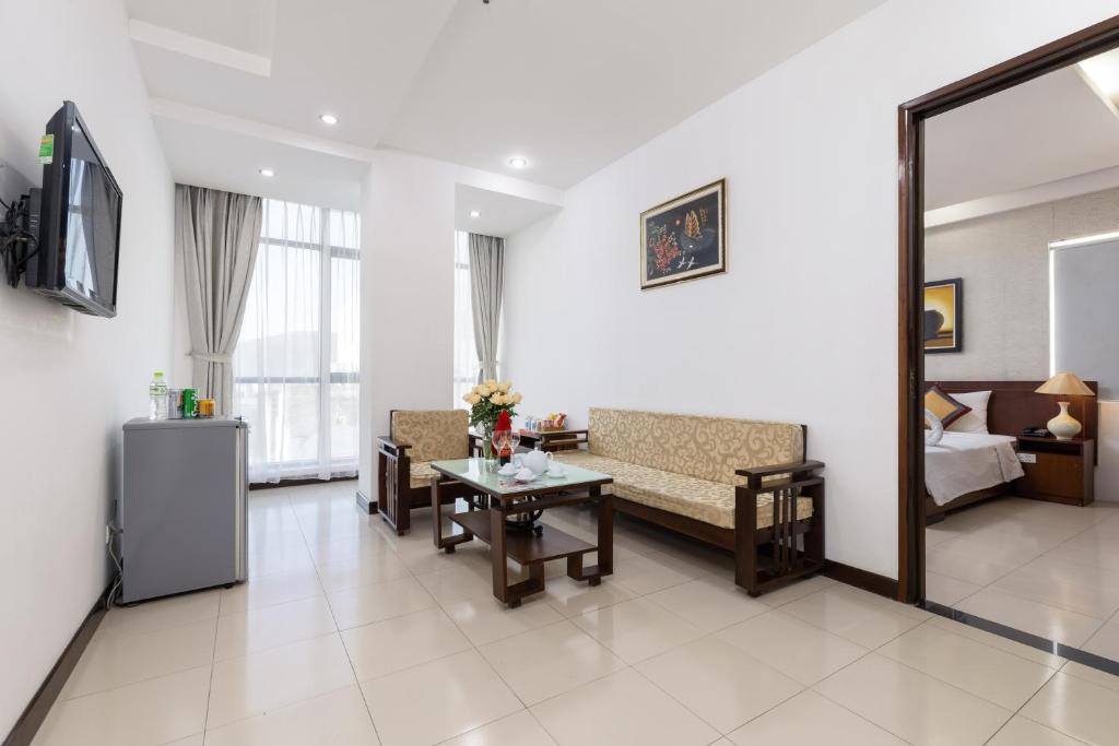 a living room with a couch and a table at Star Hotel and Spa Danang in Danang