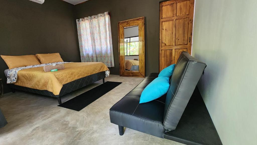 DS House في Cabuya: غرفة نوم بسرير ومخدة زرقاء على كرسي