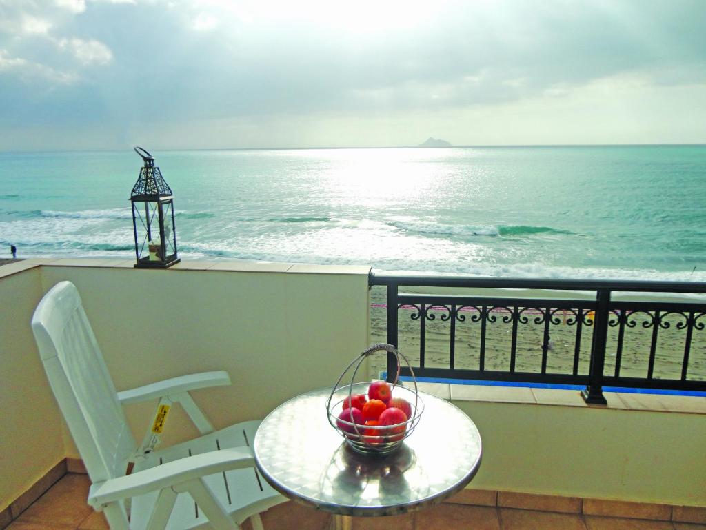 a bowl of fruit on a table on a balcony with the ocean at Studio Anessis in Kalamaki