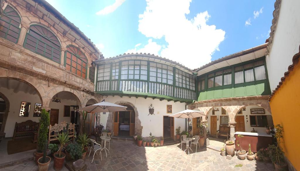 un patio con mesas y sombrillas en un edificio en La Llave 351, en Cusco