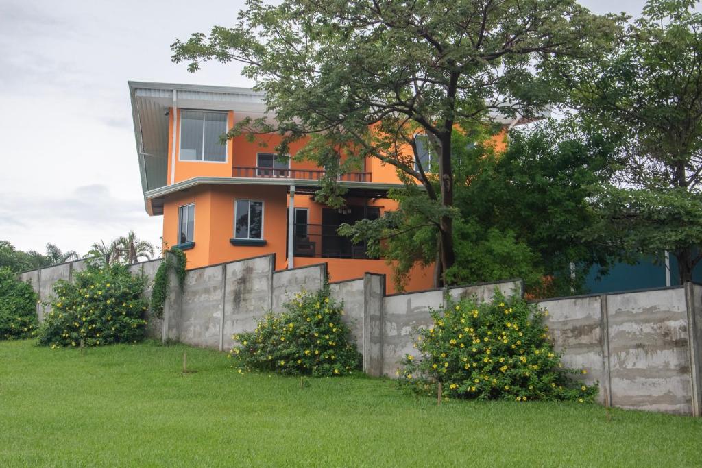 an orange house behind a fence in a yard at Organic Garden in San José