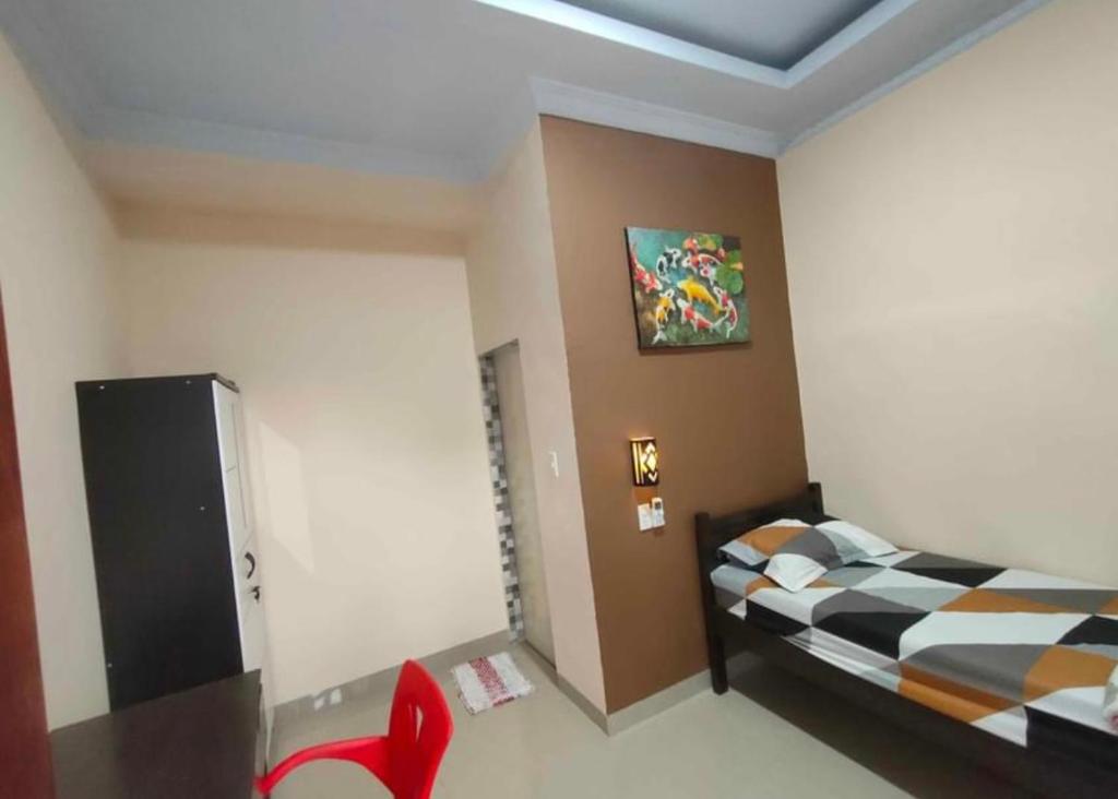 Pulauberayan的住宿－Private guest house，卧室配有一张床,墙上挂有绘画作品